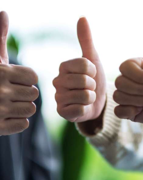 A group of people making thumb up hands sign